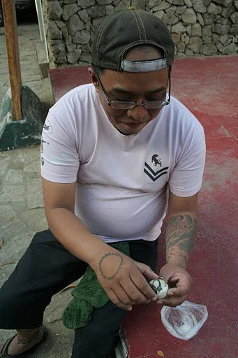Guide JB preparing balut for an adventurous tourist