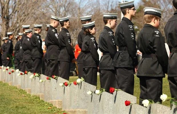 Canadian Sea Cadets stand next to grave of victims of the Titanic disaster