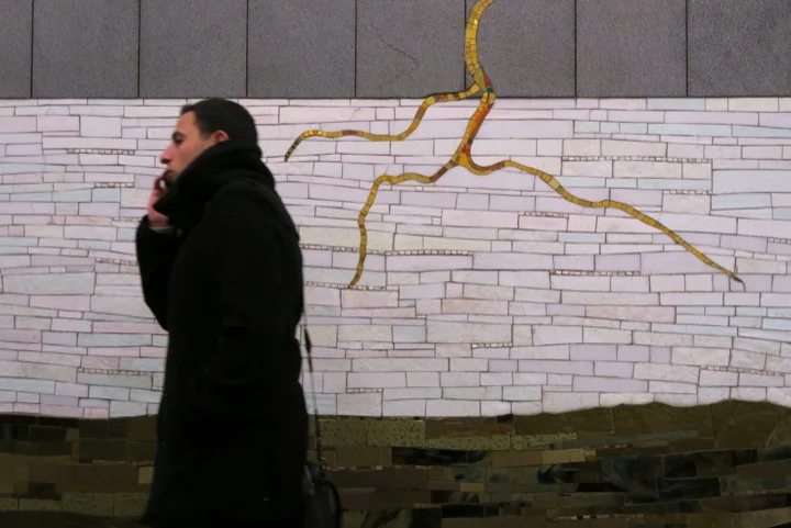 A New Yorker walks past the mosaic at 42nd St and 6th Ave, Manhattan