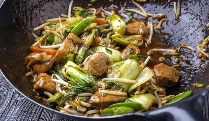 Traditional stir fried Chicken Gung Bao with Vegetable as close-up in Wok