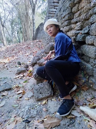 sitting by the wall of Si Satchanalai Historical Park