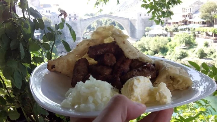 traditional bosnian "Čevapi" with beautifull Mostar old bridge view